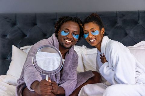 African american couple enjoying cozy bedtime skincare routine with eye patches and robes