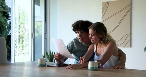 Young couple discussing documents at modern home