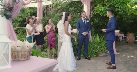 Outdoor wedding ceremony with joyful bride and groom surrounded by loved ones