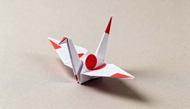 Origami crane featuring red circle motifs on white paper, minimalist japanese flag design