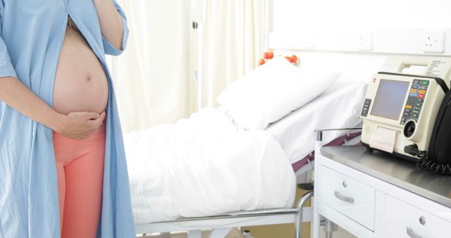 Pregnant Woman in Hospital Room Holding Belly Near Hospital Bed - Download Free Stock Images Pikwizard.com