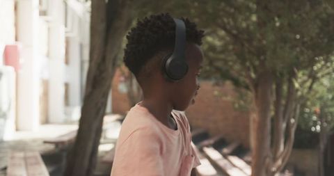 Happy Child Enjoying Music on Headphones Outdoors
