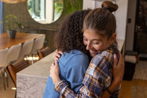 Diverse Female Friends Embracing in Modern Home Interior