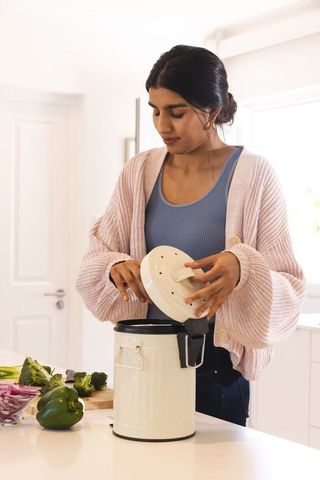 Young Woman Preparing Compost in Eco-Friendly Kitchen