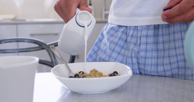 Man Pouring Milk into Bowl of Cereal in Blue Plaid Pajamas - Download Free Stock Images Pikwizard.com