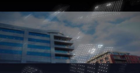 Blue-gray office tower reflecting dotted led lights over urban block, red-brick building