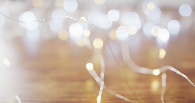 Image of lit fairy lights christmas decorations and bokeh lights on wooden background. christmas, tradition and celebration concept.