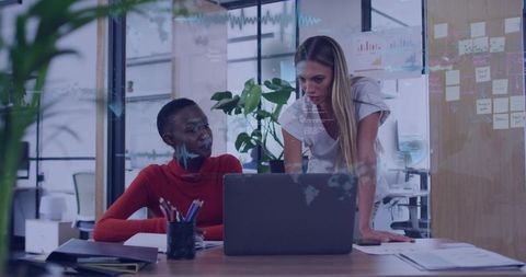 Collaborative Colleagues Discussing Over Laptop in Modern Office