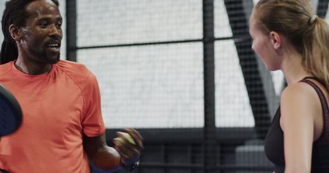 Padel coach instructing female trainee in training session