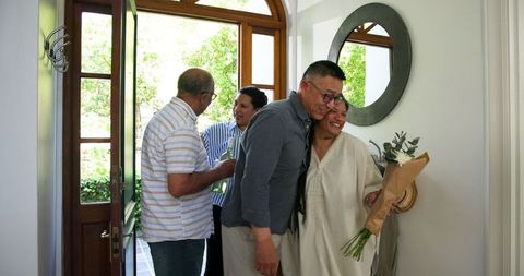 Seniors Welcoming Friends with Hugs and Gifts