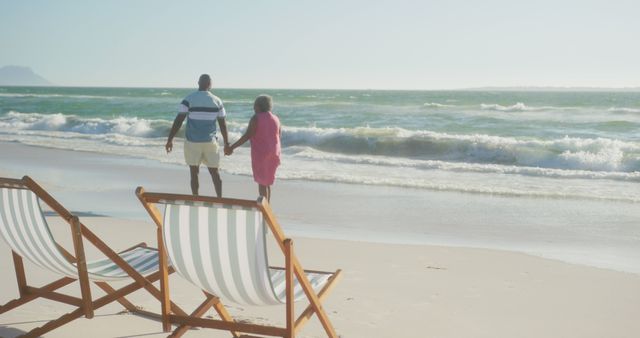 Happy senior african american couple holding hands and walking on sunny beach at sunset, copy space - Download Free Stock Photos Pikwizard.com