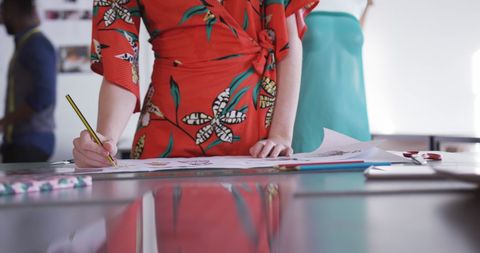 Female fashion designer sketching floral pattern