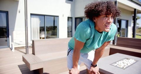 Young Man Catches Breath Post-Workout on Modern Patio