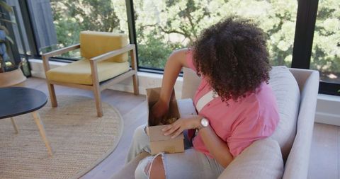 Woman Enjoying Bright Living Room and Surprise Gift Box at Home