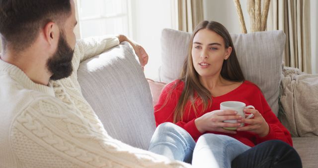 Image of happy caucasian couple siting on sofa and drinking coffee. Domestic lifestyle and leisure at home.