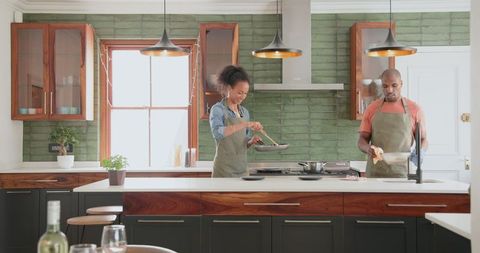 Diverse Couple Cooking Together in Modern Kitchen with Joy