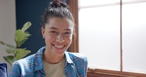 Smiling Teenage Girl Relaxing at Home by Sunlit Window