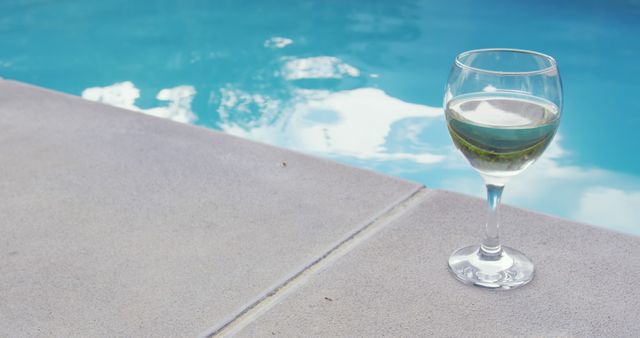Close-up of drink in glass near swimming pool in the backyard. Turquoise water in the backyard 4k