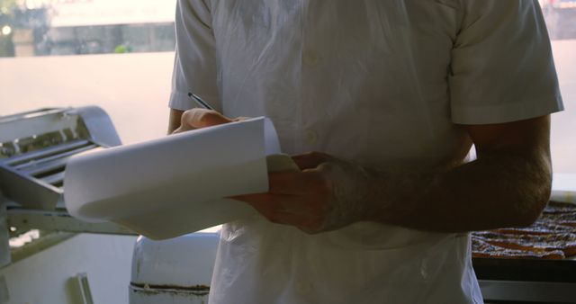 Man Writing on Clipboard in Commercial Kitchen - Download Free Stock Images Pikwizard.com