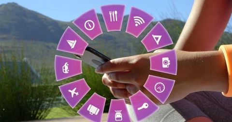 Woman using smartphone with travel icons hovering outdoors