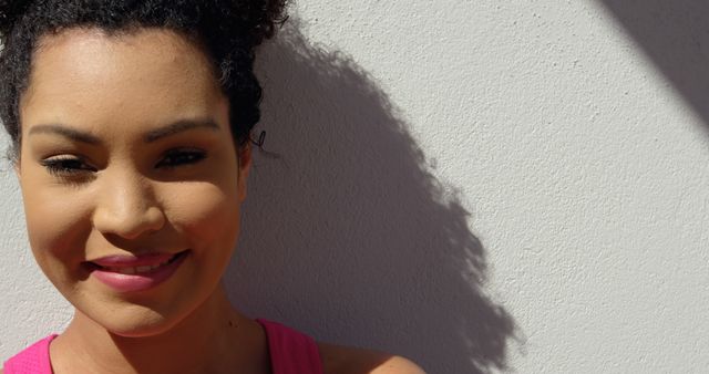 Smiling Woman in Natural Sunlight Against Wall - Download Free Stock Images Pikwizard.com