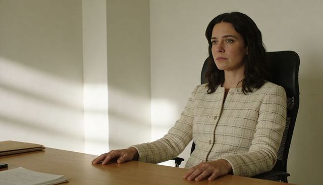 Professional woman sitting at desk reviewing documents in minimalist office