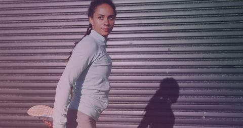 Fit woman in sportswear stretching by urban shutter