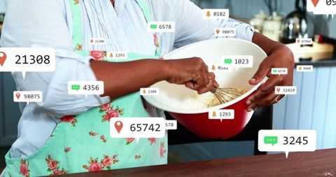 Senior woman whisking batter with digital notifications around