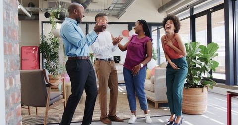 Enthusiastic Team Celebrating Success in Contemporary Office