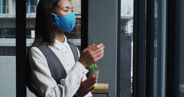 Businesswoman in office wearing mask and clapping during meeting - Download Free Stock Images Pikwizard.com