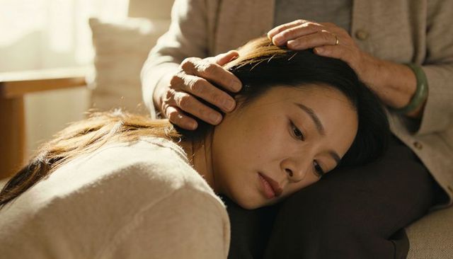 Adult woman resting on senior woman's lap receiving comforting touch and companionship