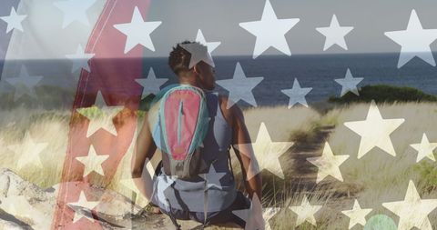 American flag overlay on african american hiker by sea