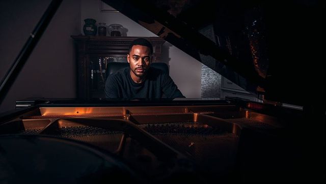 Sophisticated pianist composing music in warm, elegant music room