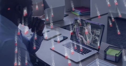 Remote collaboration and cybersecurity man watching laptop with binary data overlay office