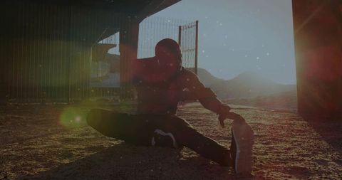 Athlete Stretching Under Urban Overpass with Sunlight Glow