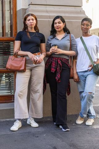 Urban friends standing with coffee and bags showcasing casual street style and diversity