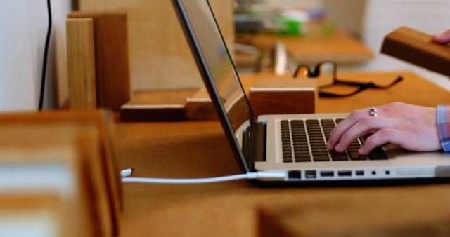 Person typing on laptop with bookshelf in background - Download Free Stock Images Pikwizard.com