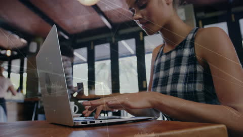 Young Woman Using Laptop with Digital Network Overlay in Cafe