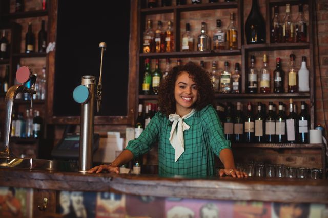 Portrait of beautiful female bar tender standing at bar counter