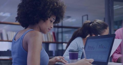 Focused Professional Woman Working on Laptop in Modern Office Environment