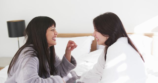 Two Women in Bathrobes Having Fun Conversation on Bed - Download Free Stock Images Pikwizard.com