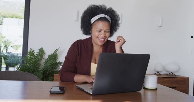 Smiling Woman with Curly Hair Using Laptop at Home Office - Download Free Stock Images Pikwizard.com