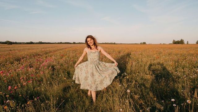 Joyful Woman in Floral Dress Enjoying Wildflower Meadow