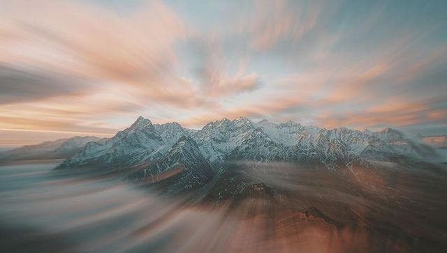 Snow-Capped Mountains with Stunning Cloud Swirl Effect