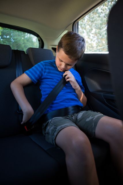 Teenage boy wearing seat belt in the back seat of car