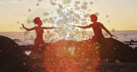 Dance Duo Performing Mirrored Pose at Sunset by Beach