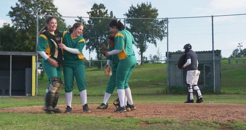 Softball team celebrating highlight moment on pitcher's mound