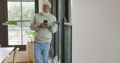Elderly Man Leisurely Using Smartphone in Cozy Home Interior