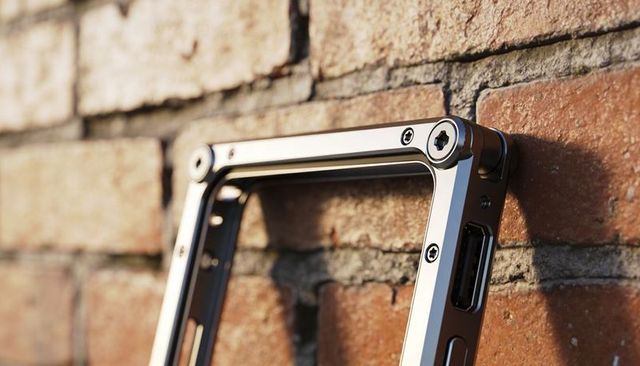 Sleek aluminum device frame mounted on brick wall with recessed screws and usb cutout