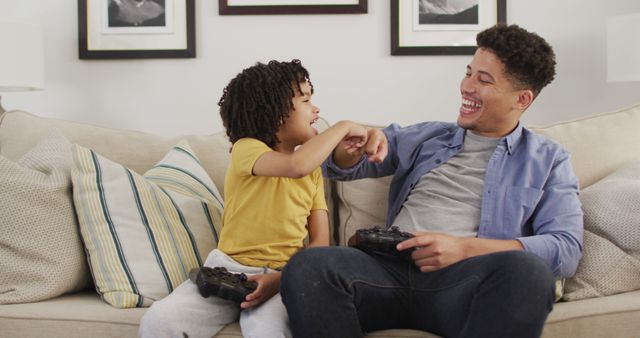 Happy biracial man and his son playing image games. domestic life, spending time at home.